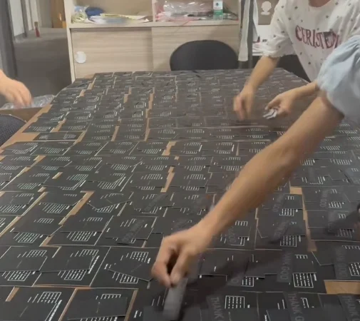 Assembly-line workflow showing workers adding the third layer of components